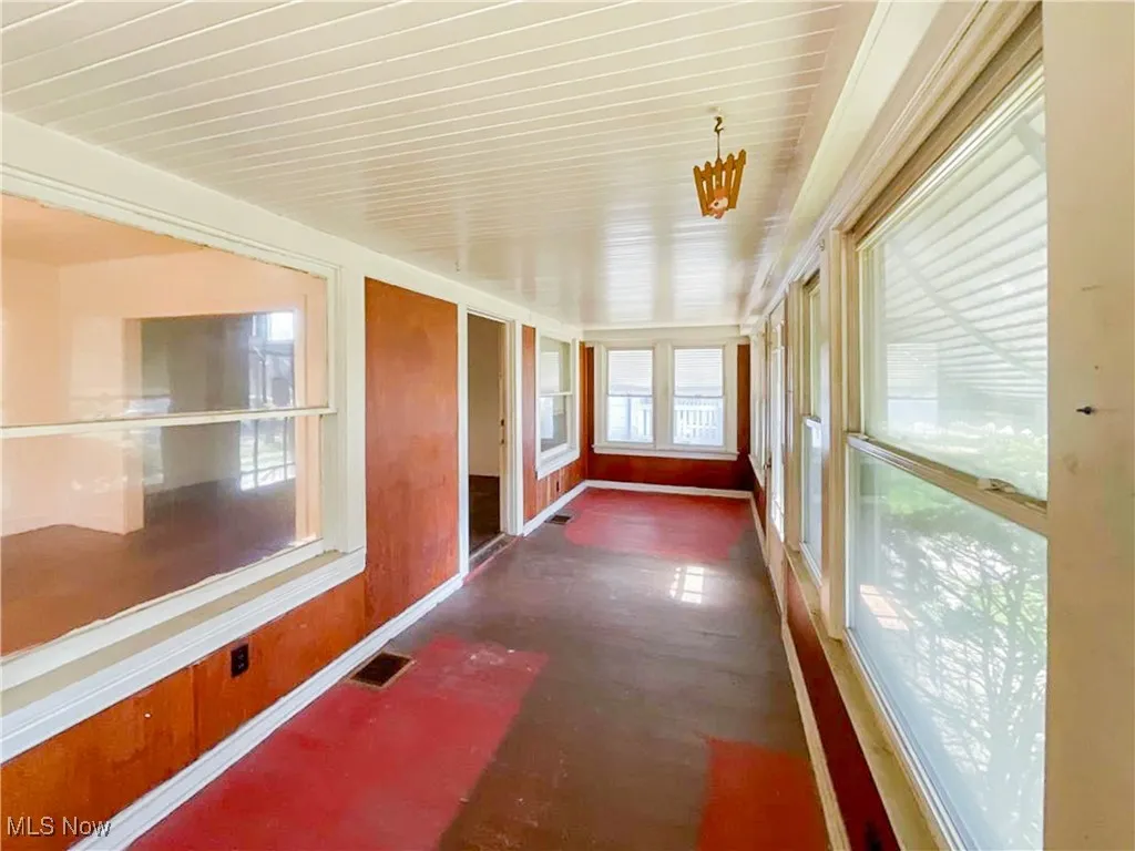 Unfurnished sunroom featuring visible vents and baseboards