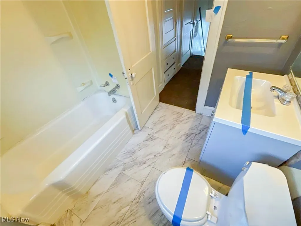 Full bath featuring toilet, marble finish floor, and vanity