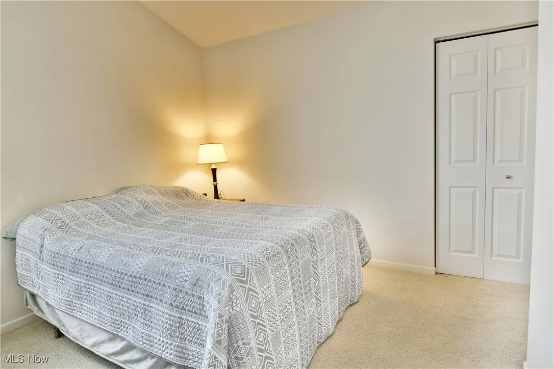 Carpeted bedroom featuring a closet and baseboards