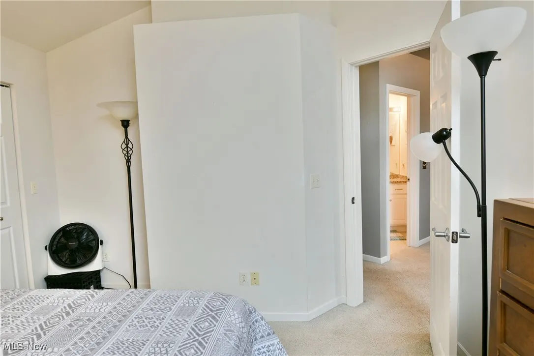 Bedroom with light colored carpet and baseboards