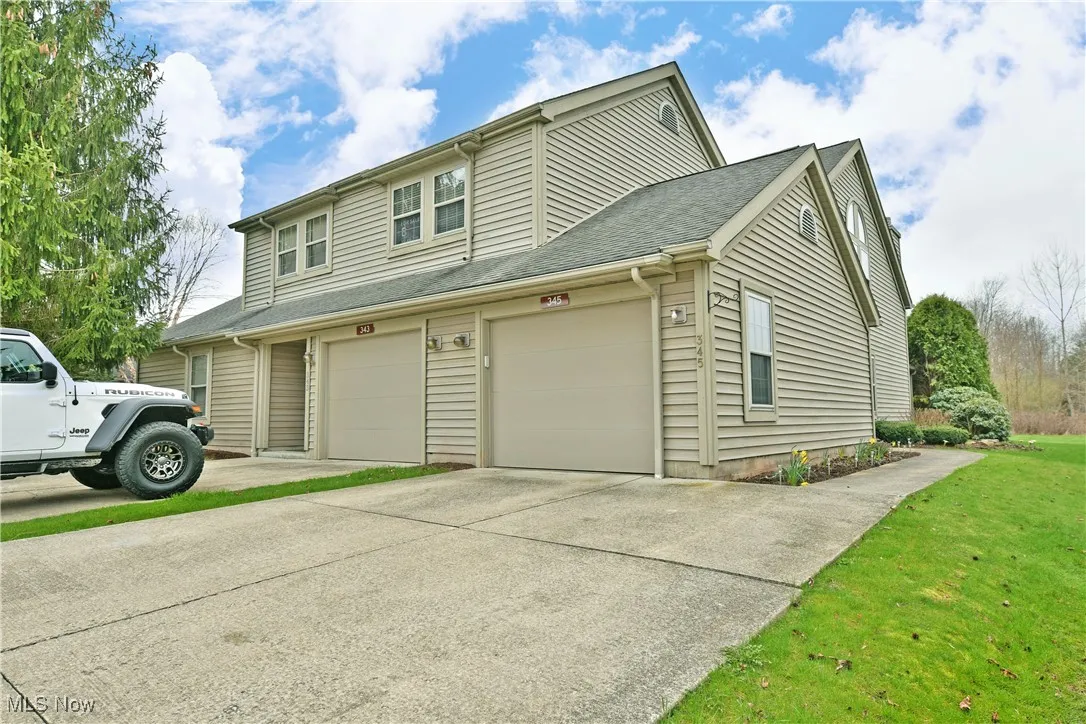 View of side of home with a lawn and driveway