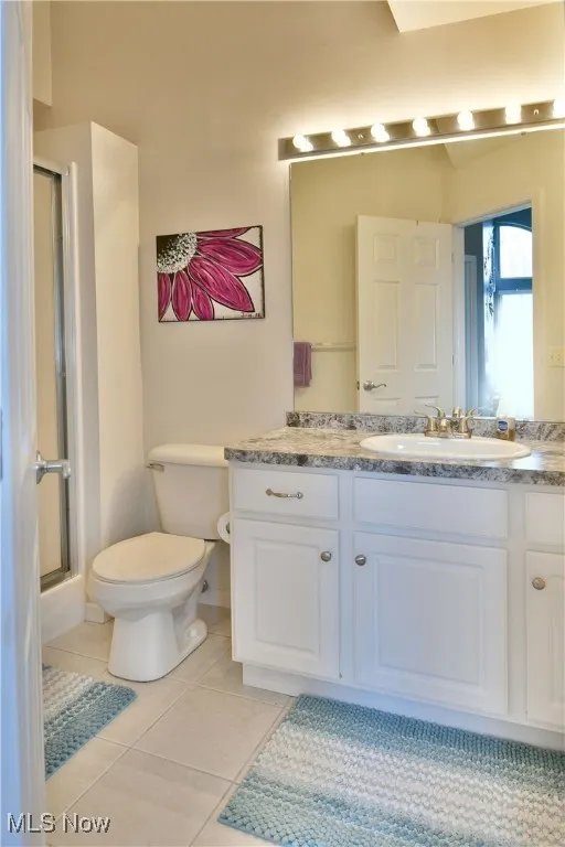 Full bath with toilet, a shower stall, tile patterned flooring, and vanity