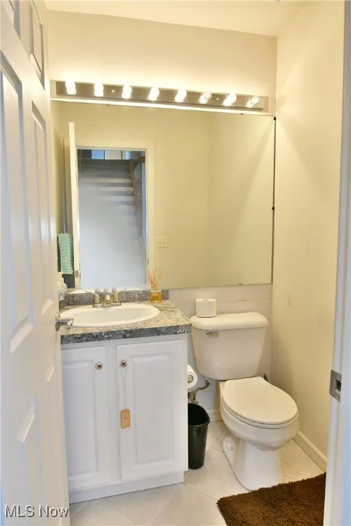 Bathroom featuring toilet, tile patterned flooring, and vanity