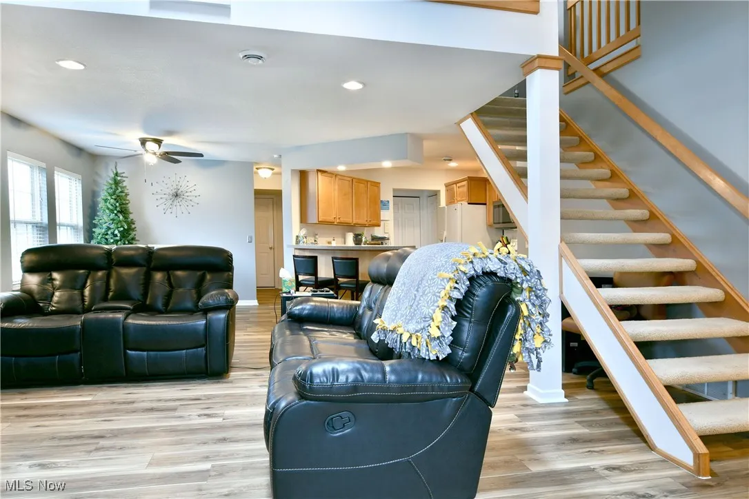 Living room featuring stairway, recessed lighting, light wood finished floors, and a ceiling fan