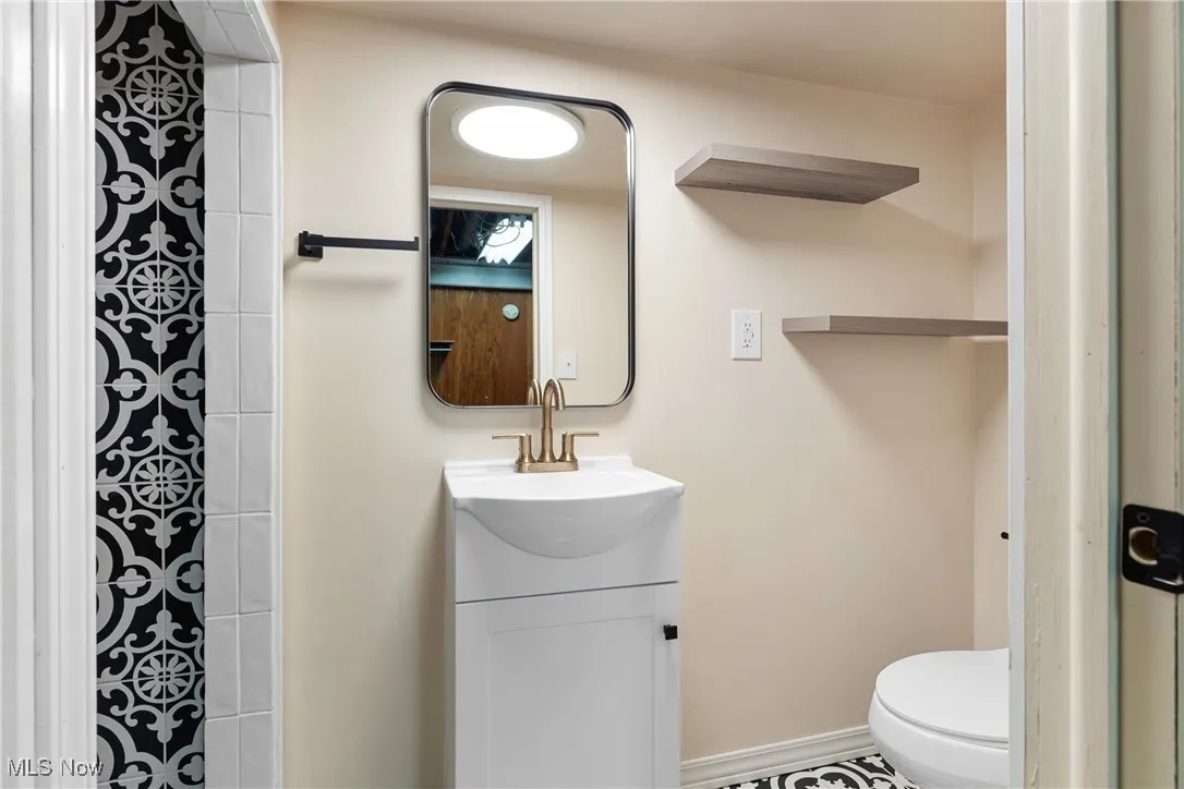 Bathroom with toilet, a shower, and vanity