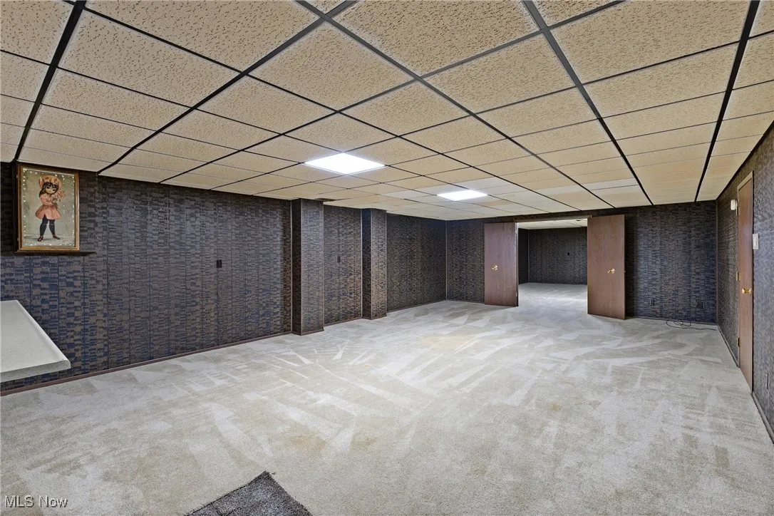 Finished basement with light carpet and a drop ceiling