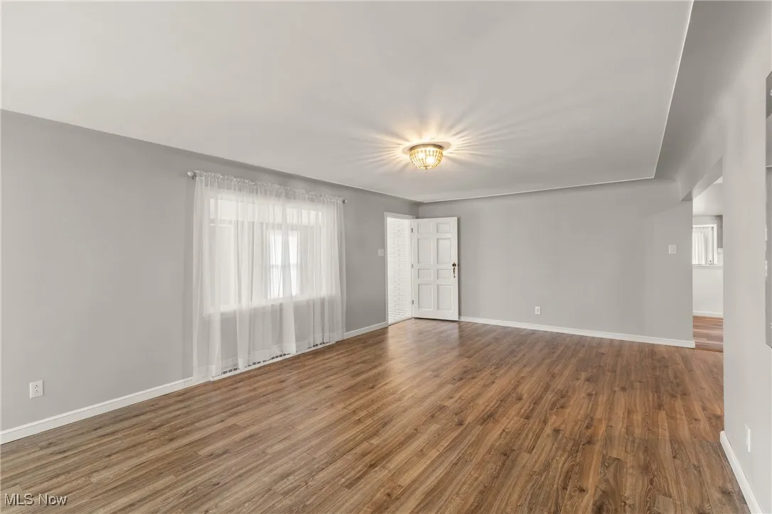 Unfurnished room featuring baseboards and wood finished floors
