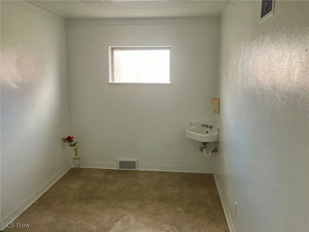 Bathroom with visible vents, baseboards, and a sink