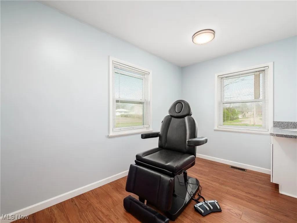 Sitting room with visible vents, baseboards, and wood finished floors