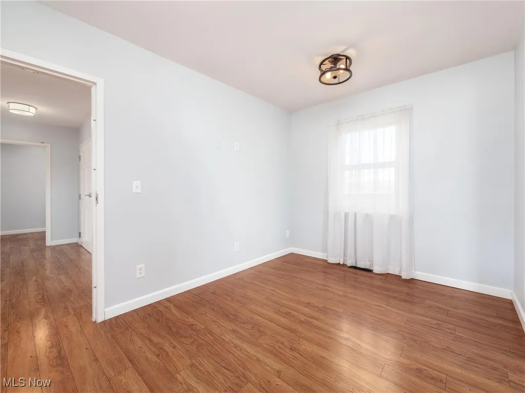 Spare room with baseboards and wood finished floors