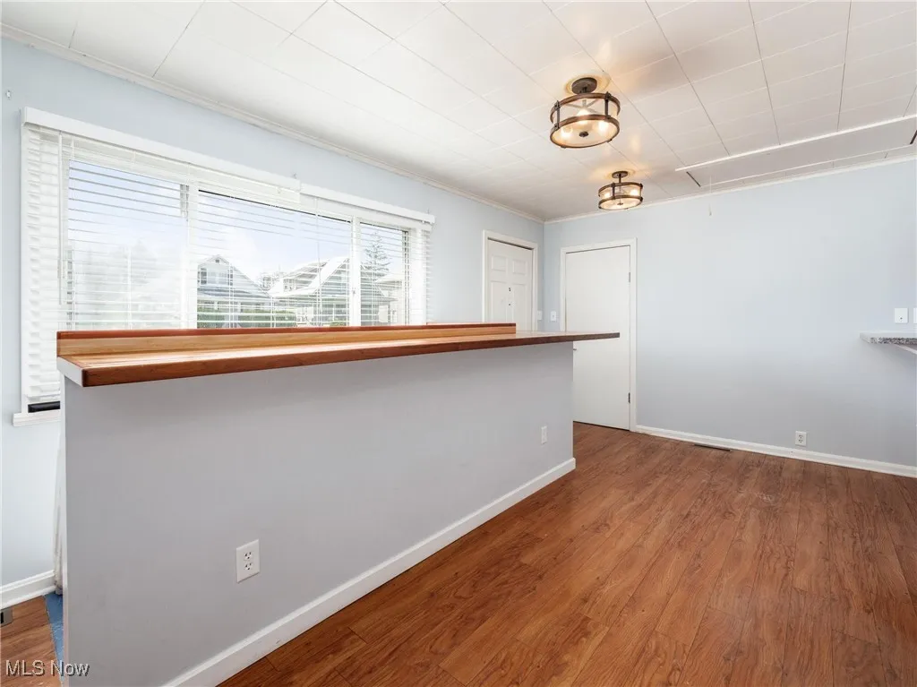 Spare room featuring baseboards, attic access, and wood finished floors