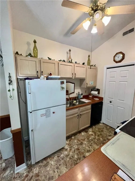 Kitchen with visible vents, dishwasher, a sink, freestanding refrigerator, and a ceiling fan
