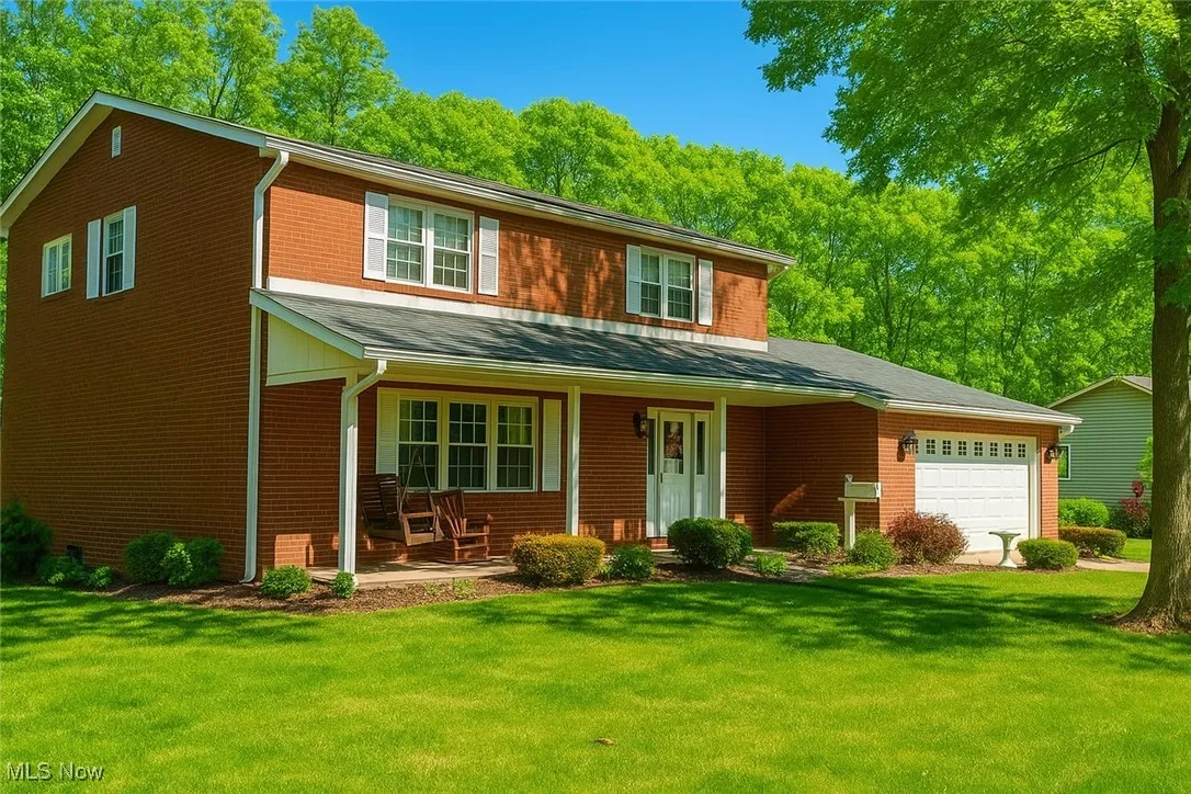 Traditional-style house with covered porch, a front yard, and brick siding