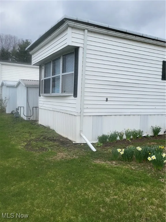 View of side of home with a yard