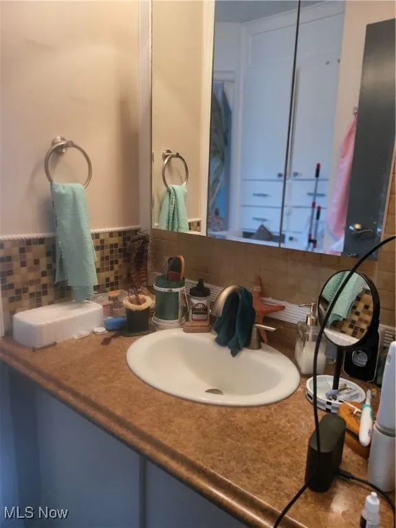 Bathroom featuring vanity and backsplash