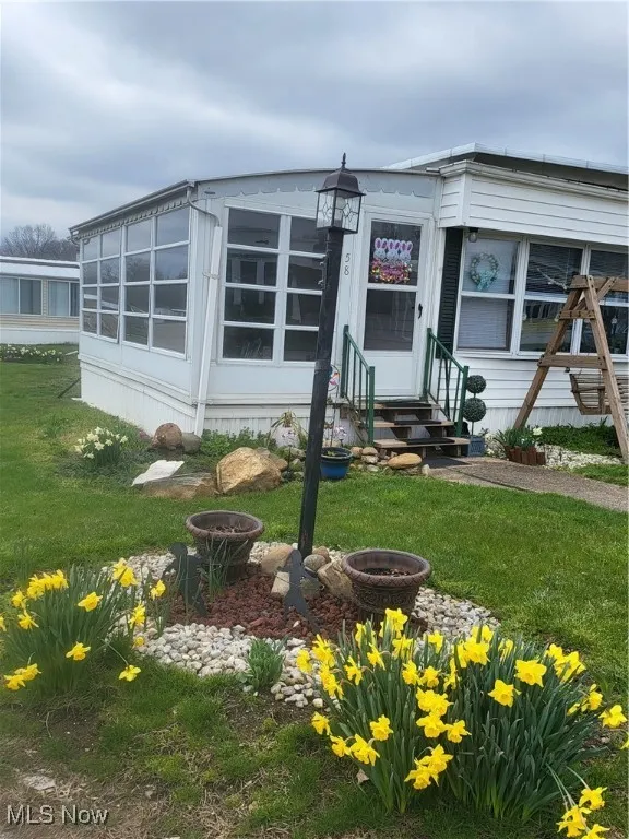 Manufactured / mobile home with entry steps and a front lawn