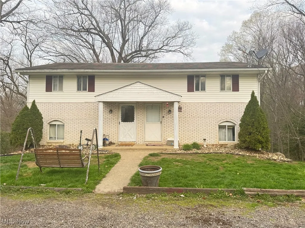 View of front of house featuring a front yard and brick siding