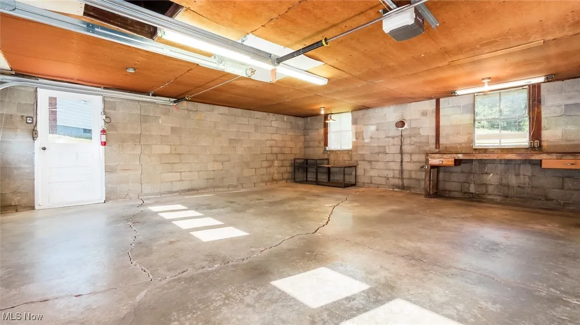 Below grade area with a garage, plenty of natural light, and concrete block wall