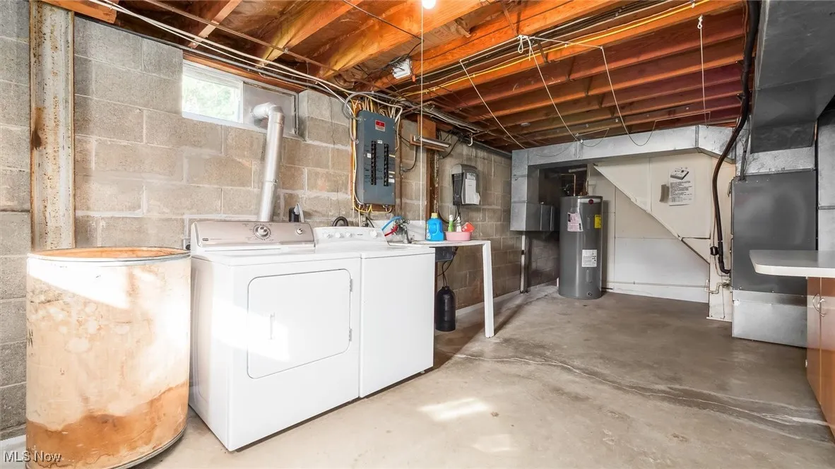 Basement with electric water heater, washer and clothes dryer, and electric panel