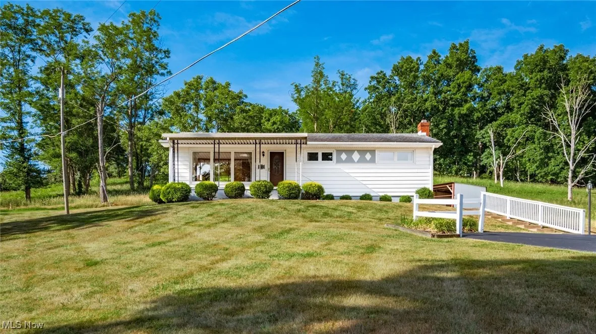 View of front facade featuring a front lawn and fence