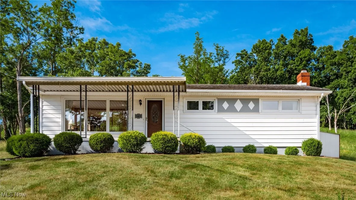 Single story home with a chimney and a front yard