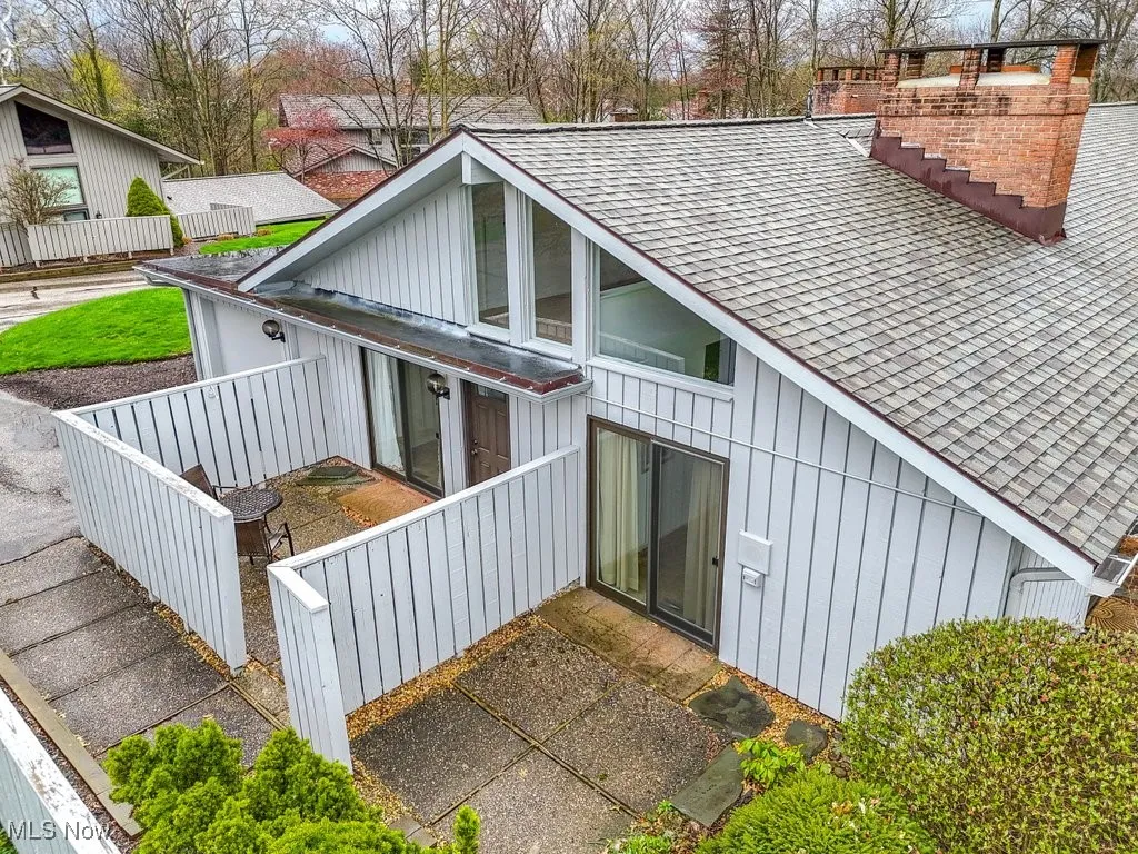 Back of property featuring a shingled roof