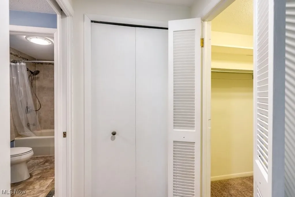 Full bath featuring toilet, a closet, and shower / bath combo with shower curtain