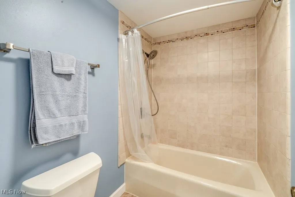 Bathroom featuring shower / bath combo and toilet