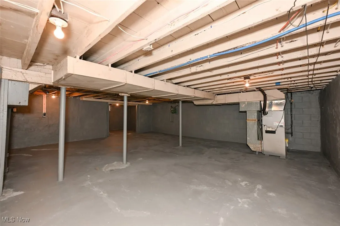 Unfinished below grade area featuring heating unit
