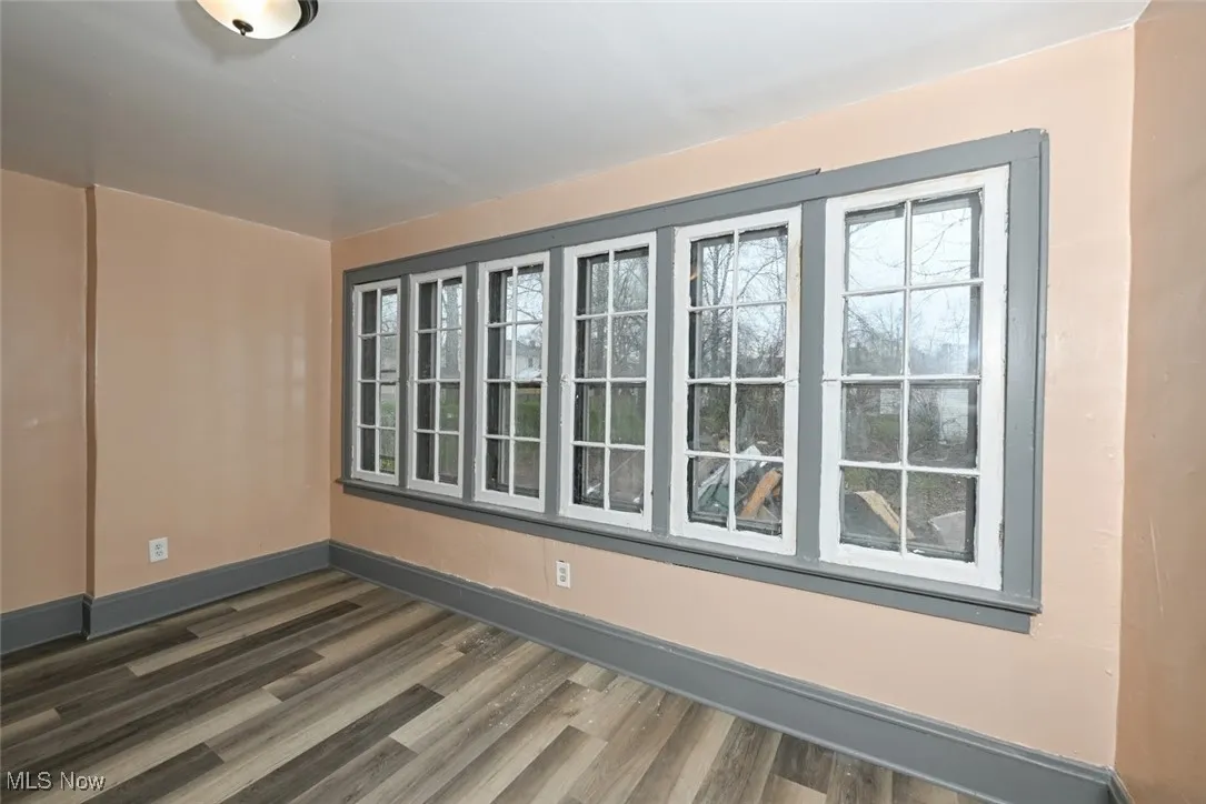 Empty room with baseboards and dark wood finished floors