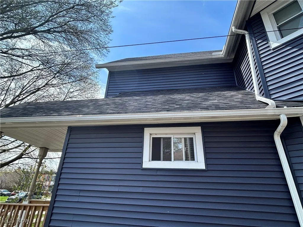 View of side of home featuring roof with shingles