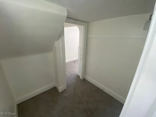 Hall with carpet flooring and baseboards