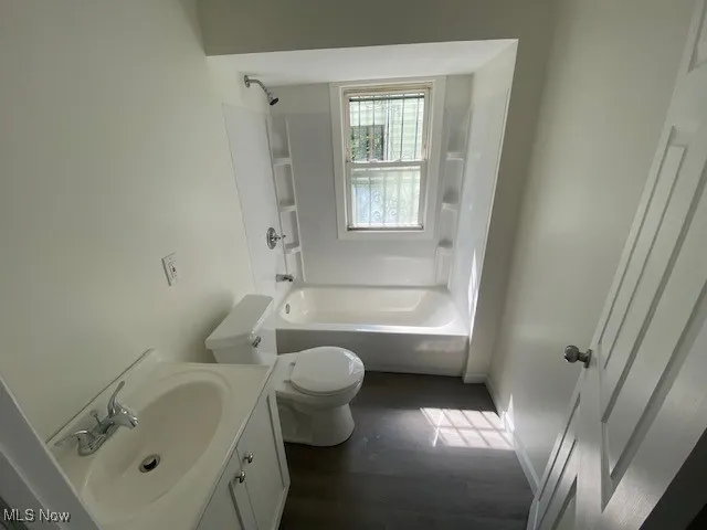 Bathroom featuring vanity, shower / bathtub combination, and wood finished floors