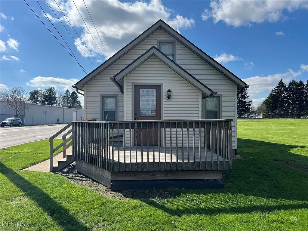 Front of house featuring a lawn and a deck