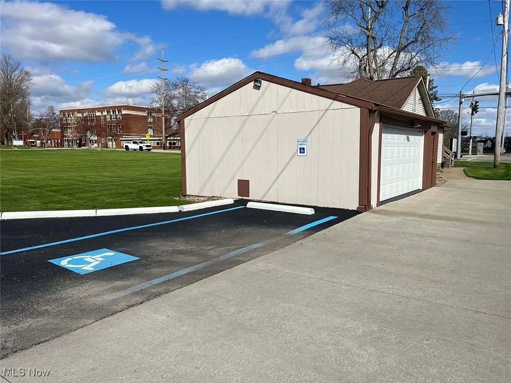 View of detached garage featuring uncovered parking