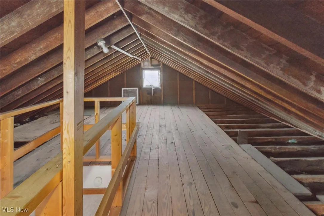 Unfinished attic with an upstairs landing