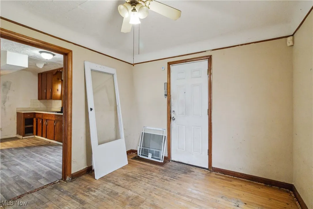 Unfurnished room with light wood-style flooring, a ceiling fan, and baseboards