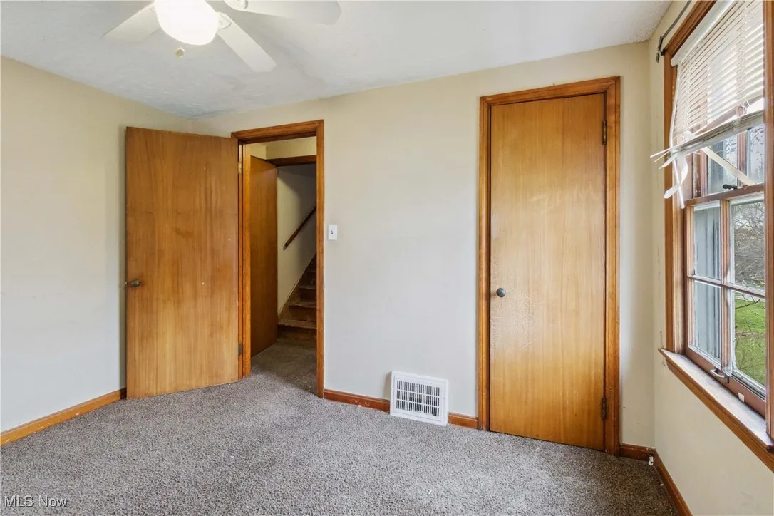 Unfurnished bedroom with baseboards, visible vents, and carpet