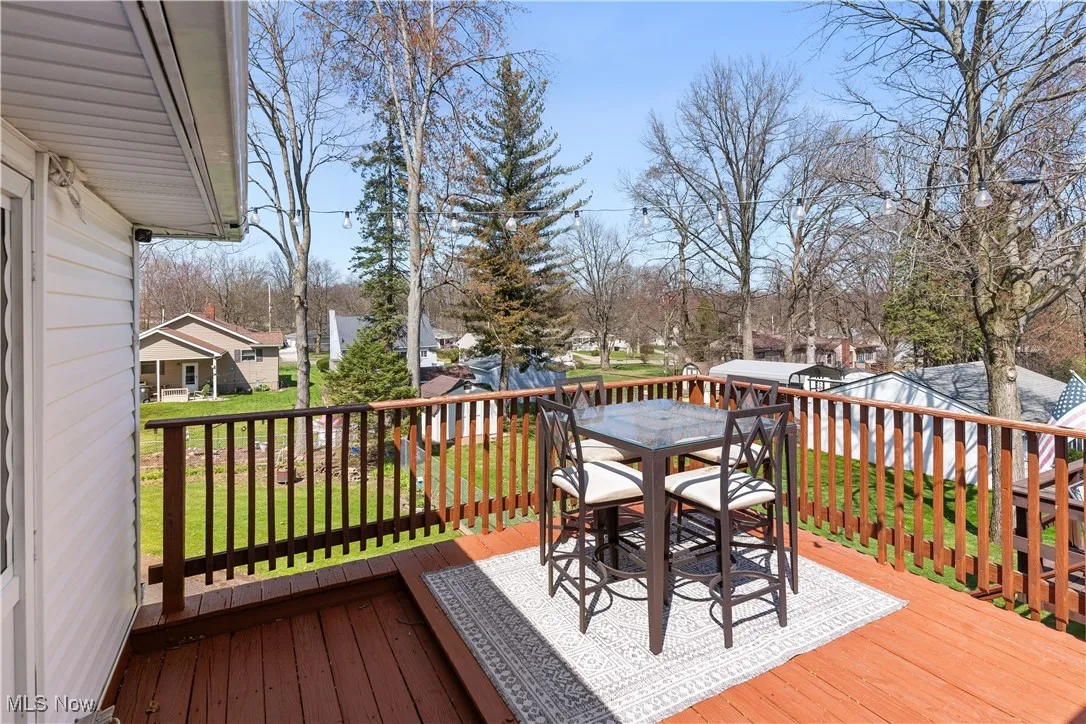 Wooden deck featuring a yard, outdoor dining area, and a residential view
