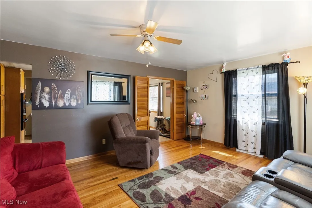 Living room with light wood finished floors and ceiling fan