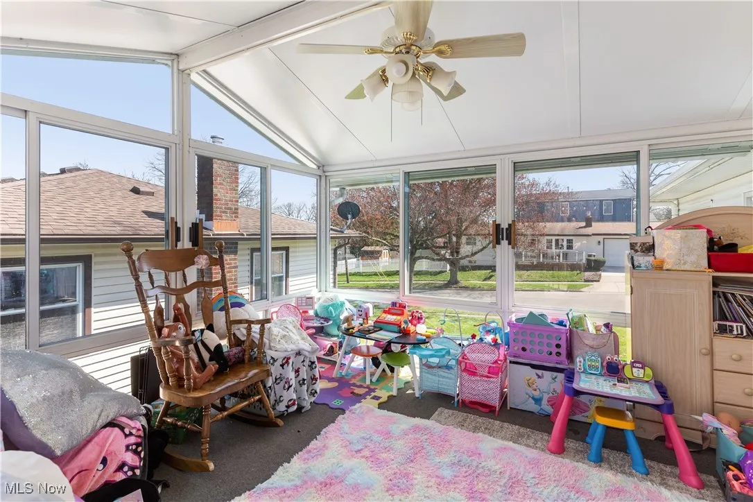 Sunroom featuring vaulted ceiling and a ceiling fan