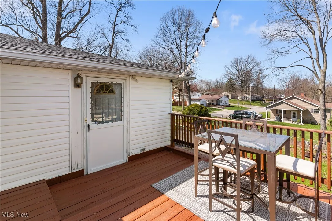 Wooden deck featuring outdoor dining space and a residential view