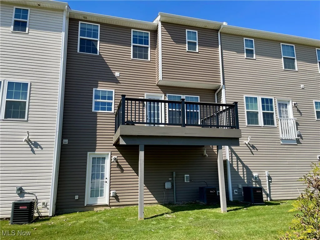 Back of house with a yard, central AC, and a deck