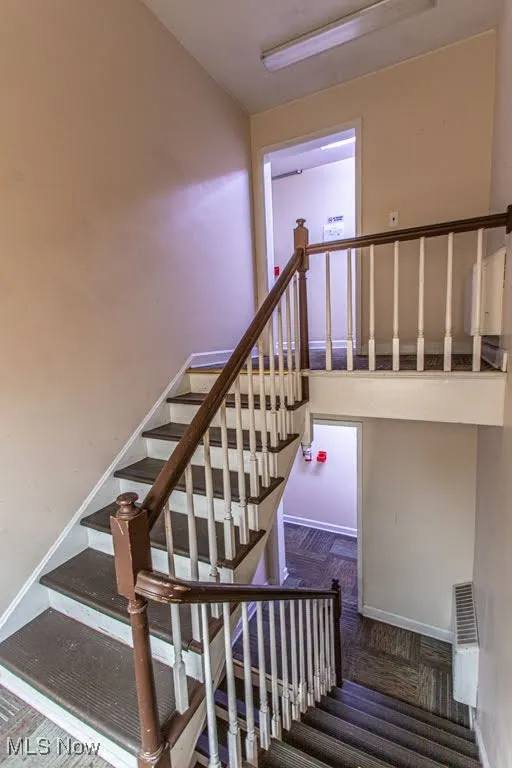 Staircase with carpet floors and baseboards