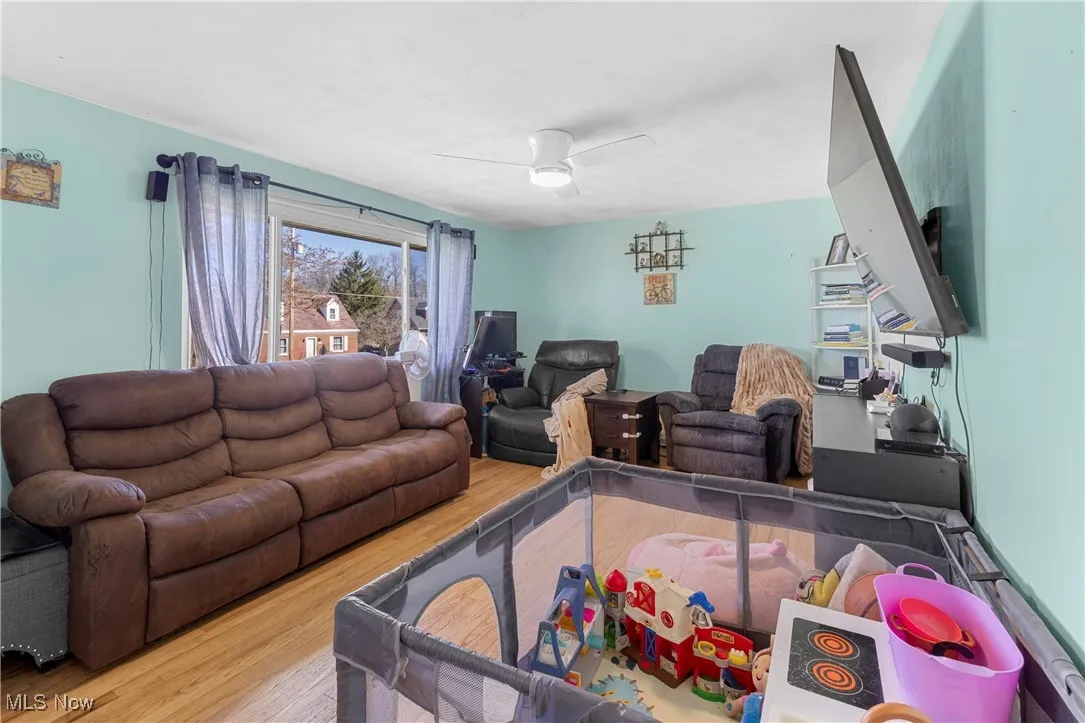 Living room with wood finished floors and a ceiling fan