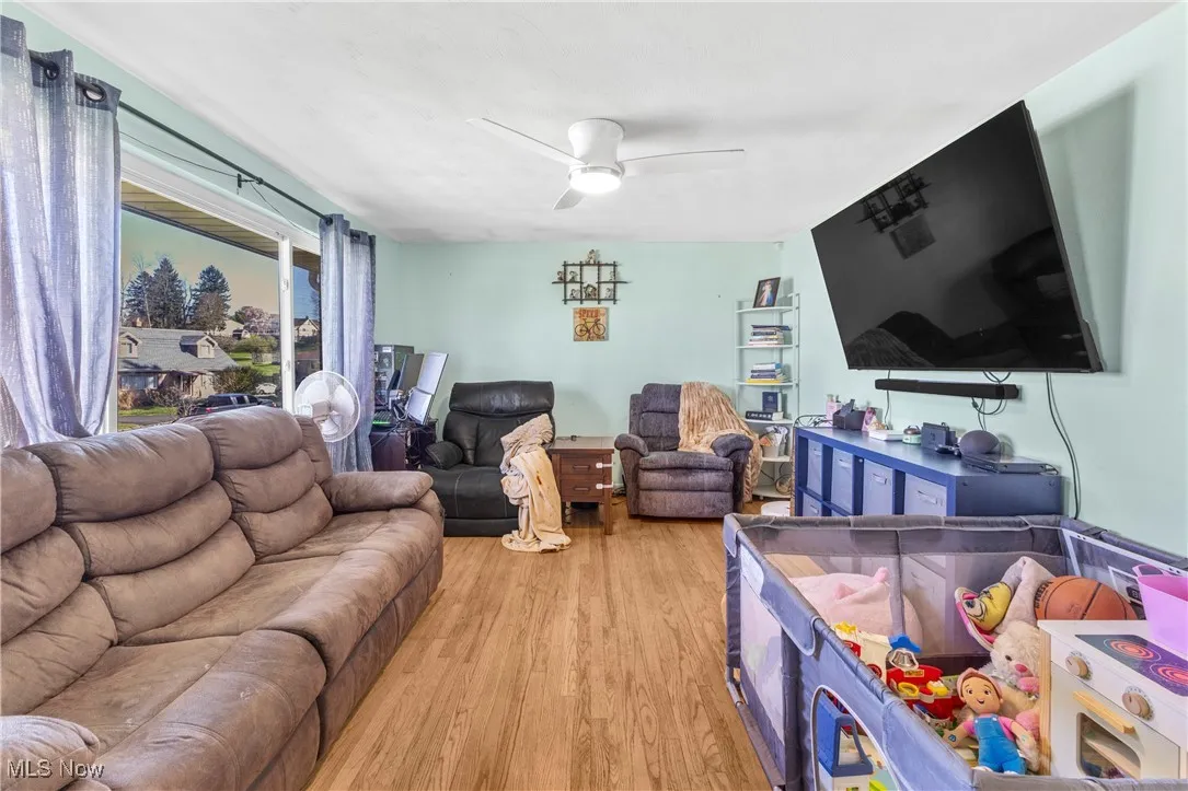 Living room with ceiling fan and light wood finished floors