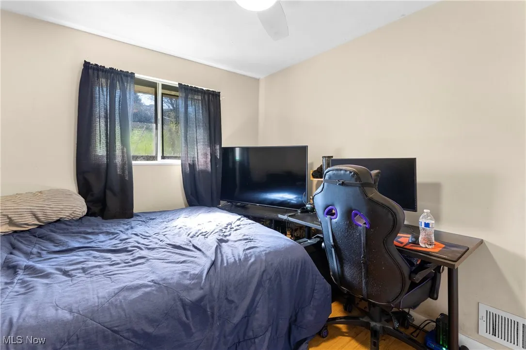 Bedroom featuring wood finished floors, visible vents, and ceiling fan