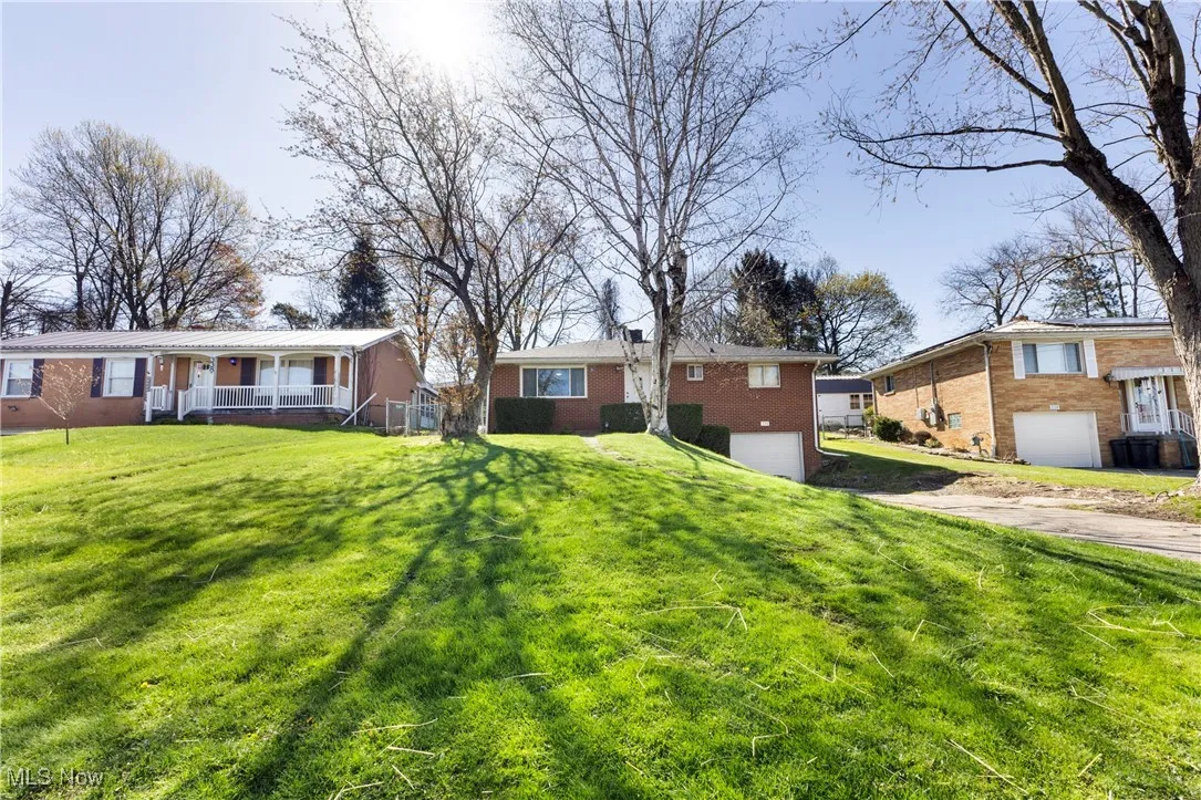 View of yard with a garage, covered porch, and concrete driveway