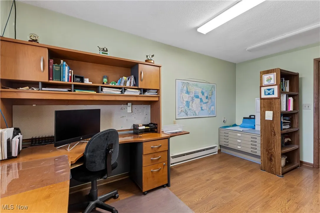 Office space featuring light wood finished floors and a baseboard radiator