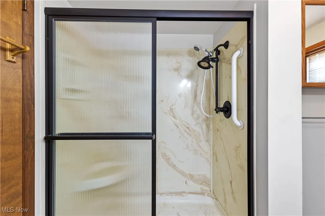 Bathroom featuring a marble finish shower